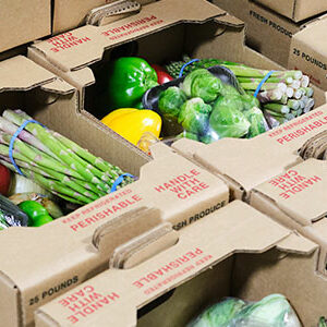 Martinous Produce boxes of fresh fruit and vegetables sit in stacks, ready for pickup or delivery.